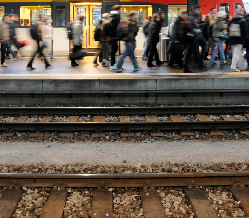 Rail passengers exiting train and leaving station